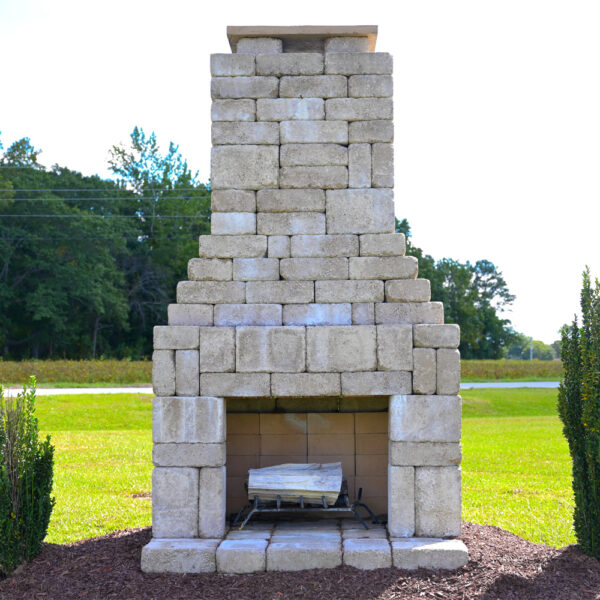 Fireplace with evergreen plants and mulch surrounding the fireplace area.